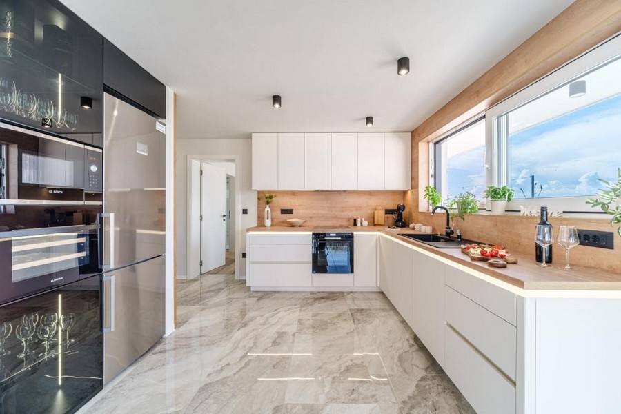 Jasna, wyposażona kuchnia z nowoczesnym sprzętem i marmurowymi płytkami