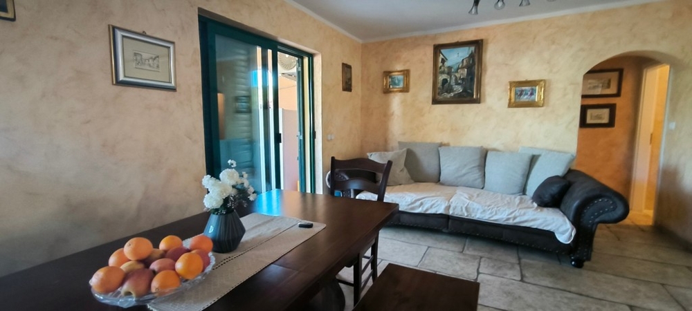 Część dzienna z sofą, stołem i wyjściem na taras