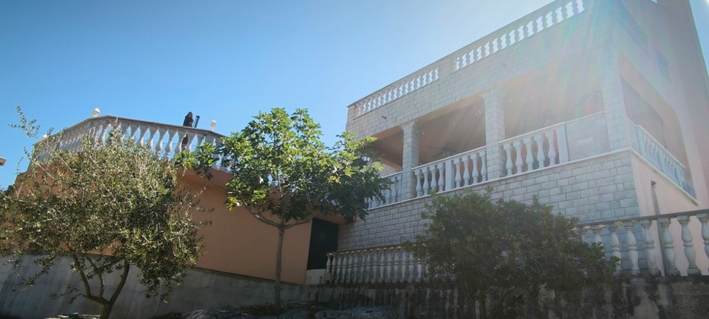 Kamienny dom z balkonem i tarasem, widok na zewnątrz