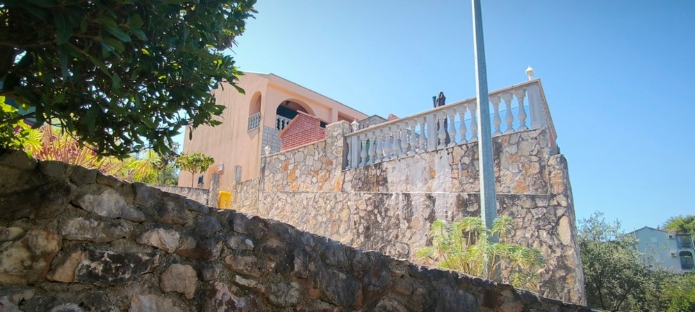 Dom na podniesionej kamiennej ścianie z tarasem