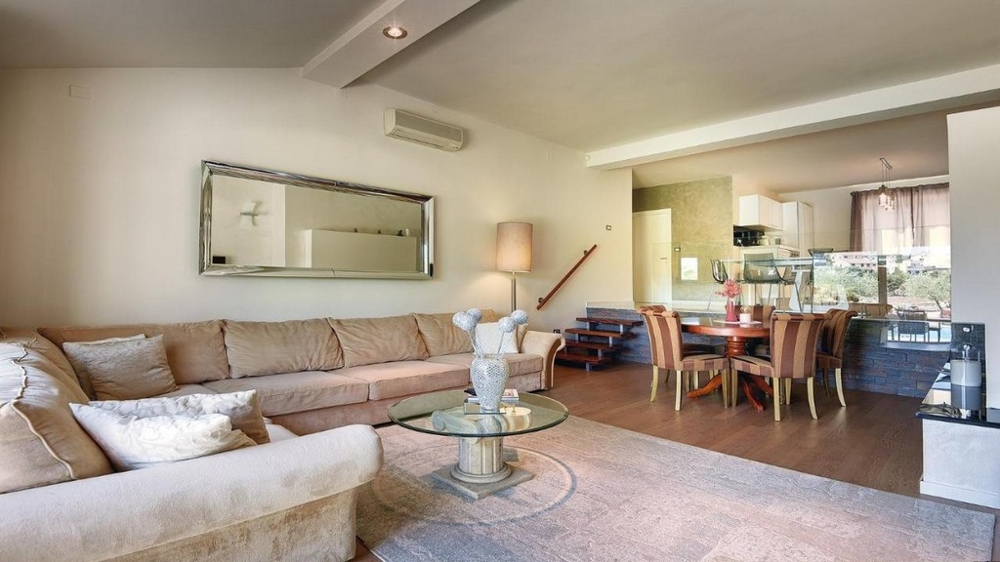 Przytulny salon z narożną sofą, lustrem i jadalnią