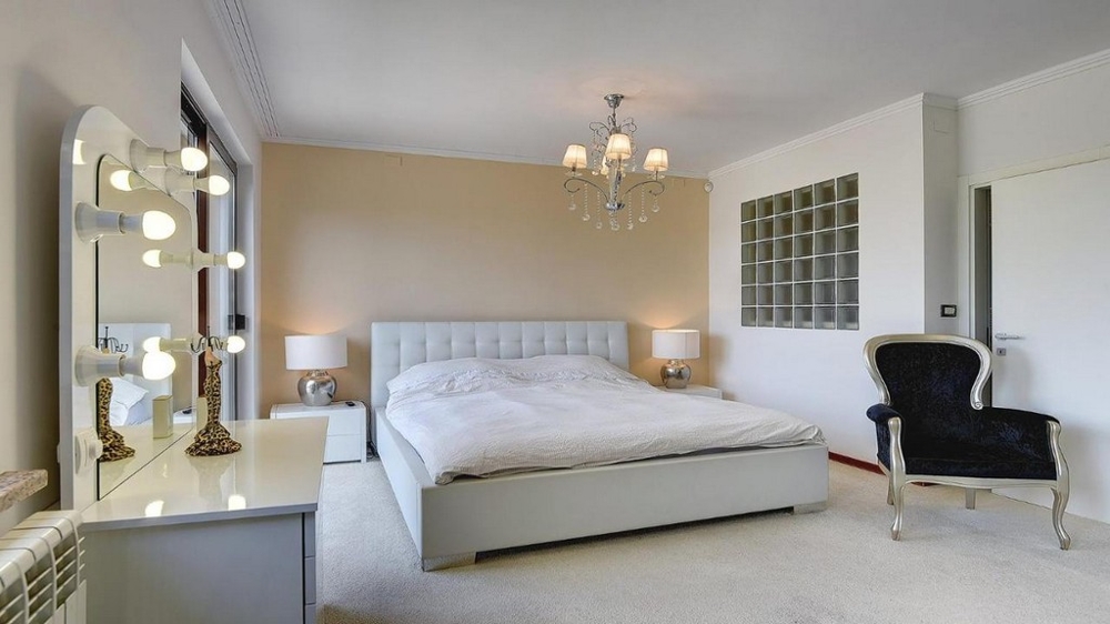 Sypialnia z podwójnym łóżkiem, toaletką i żyrandolem