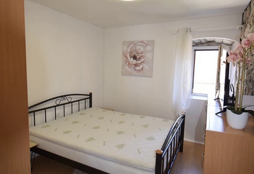 Sypialnia z podwójnym łóżkiem i kamienną ścianą