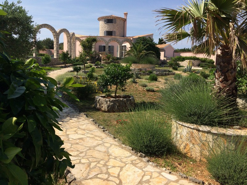 Na sprzedaż luksusowa śródziemnomorska willa z palmami w ogrodzie.