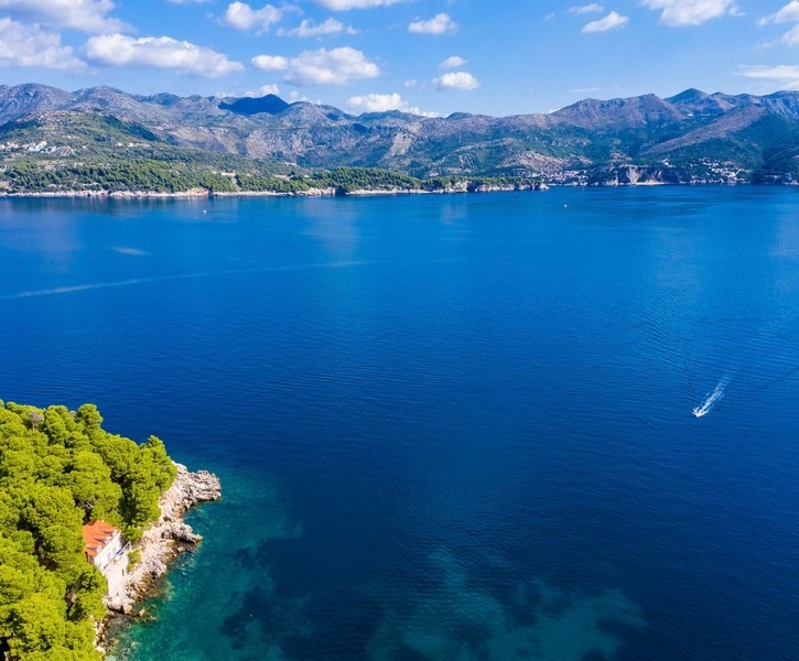 Widok z lotu ptaka na nadmorską willę z turkusową wodą