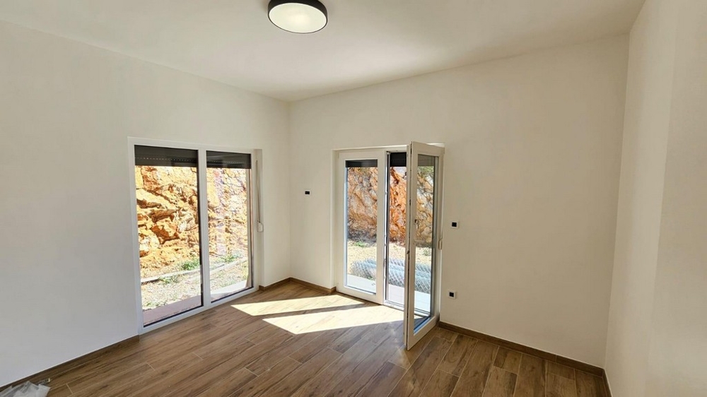 Sypialnia z oknami sięgającymi od podłogi do sufitu i widokiem na skały