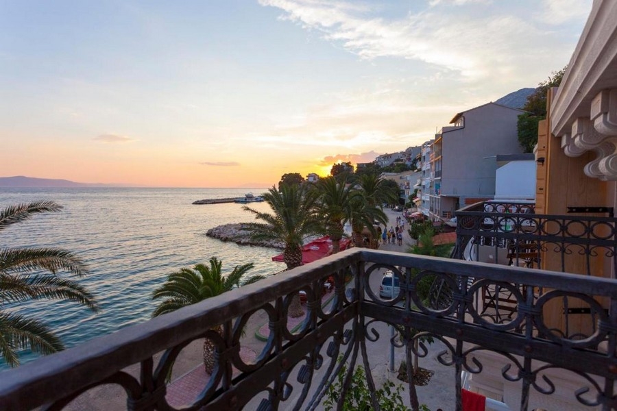 Balkon z widokiem na morze i promenadą o zachodzie słońca