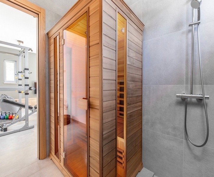 Sauna z prysznicem i sala fitness w tle