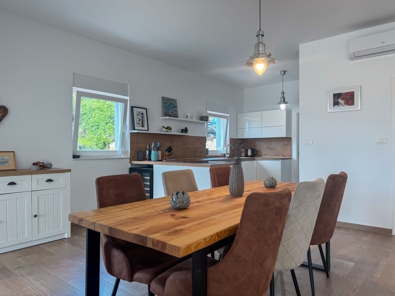 Jadalnia z drewnianym stołem i nowoczesną kuchnią