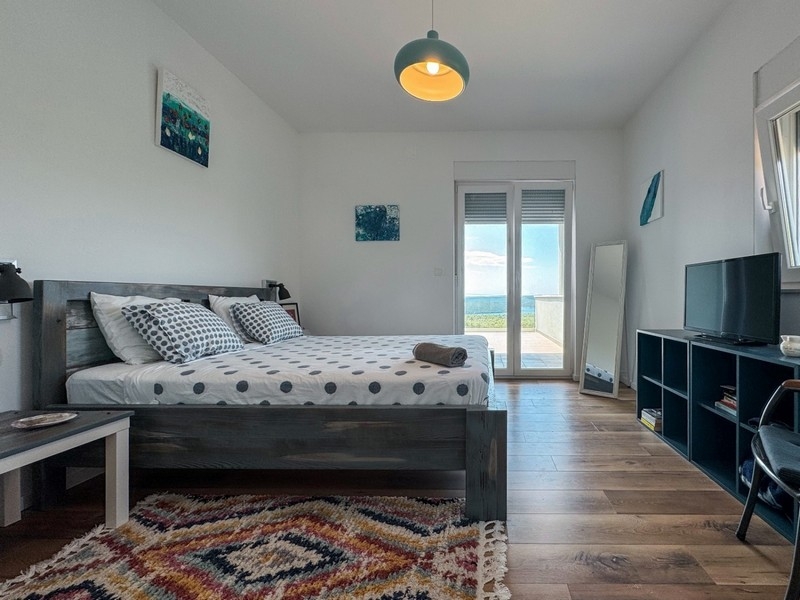 Sypialnia z łóżkiem małżeńskim i wyjściem na balkon