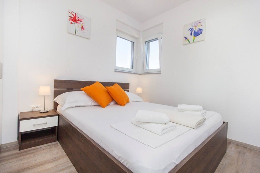 Jasna sypialnia z podwójnym łóżkiem i stolikami nocnymi