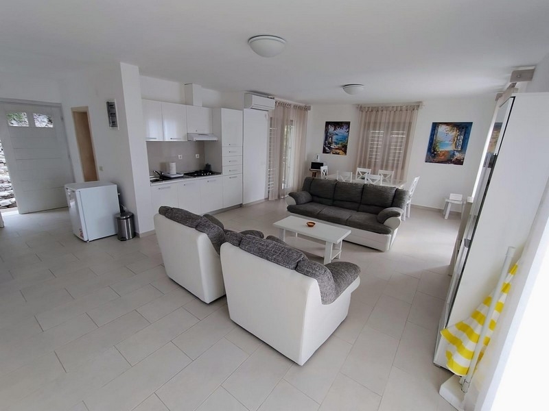 Jasny salon z otwartą kuchnią i sofami