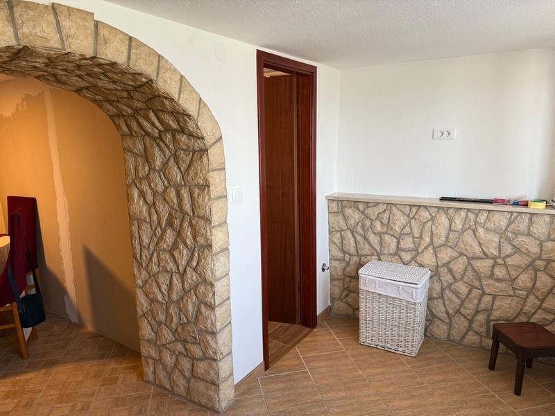 Przedpokój z kamiennym łukiem i dostępem do łazienki