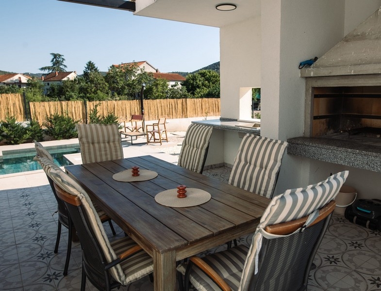 Z jadalni roztacza się widok na grill i basen.