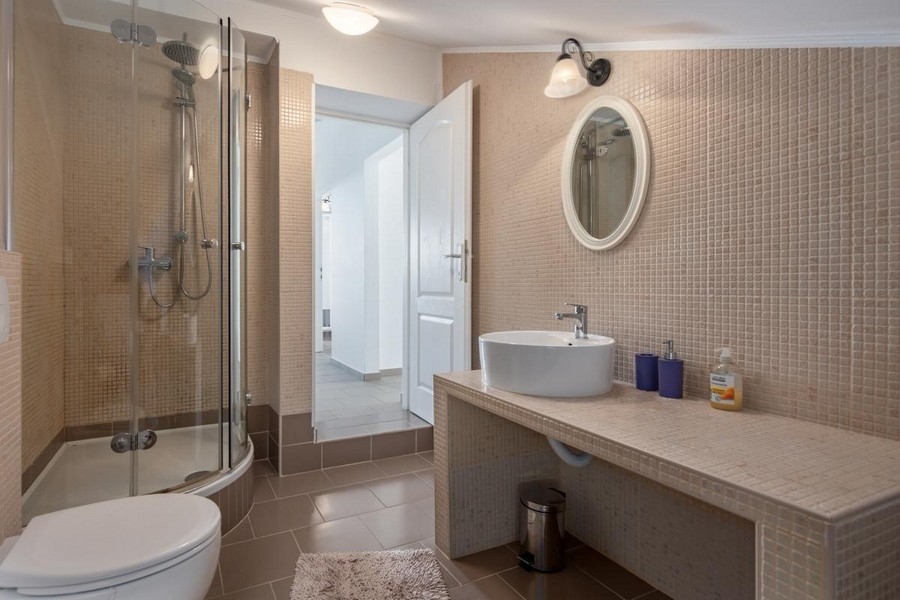 Łazienka z okrągłym prysznicem i umywalką