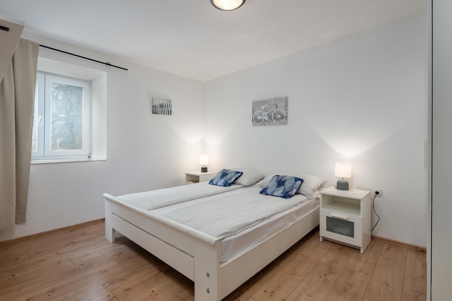 Jasna sypialnia z podwójnym łóżkiem i drewnianą podłogą