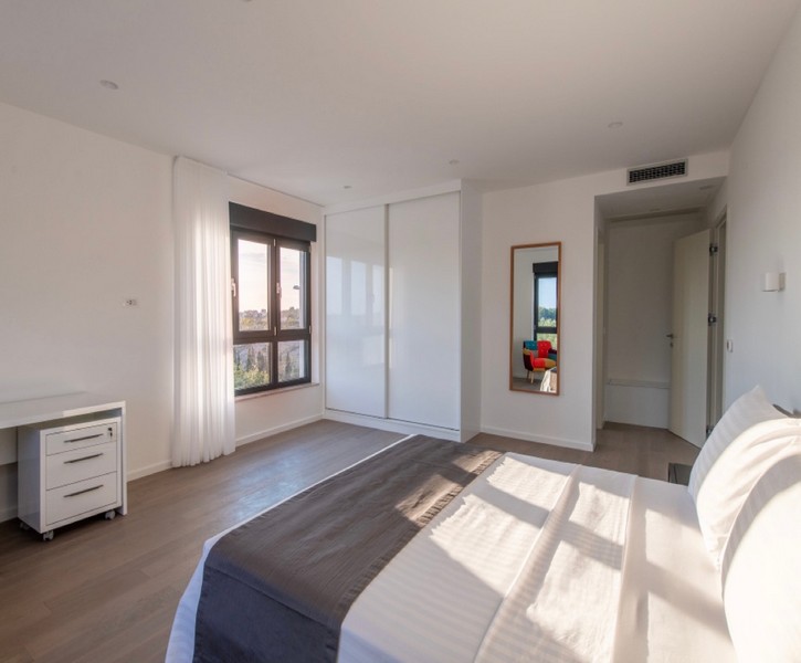 Jasna sypialnia z podwójnym łóżkiem i wbudowaną szafą