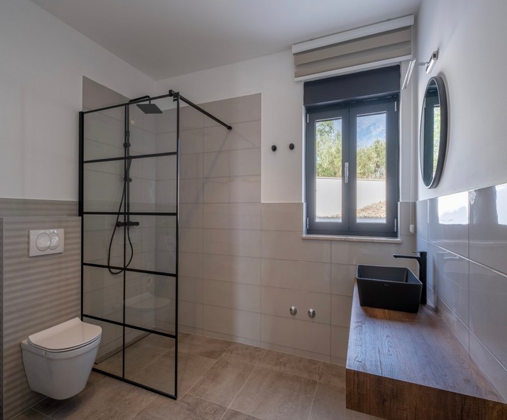 Nowoczesna łazienka z dużym prysznicem i drewnianą toaletką