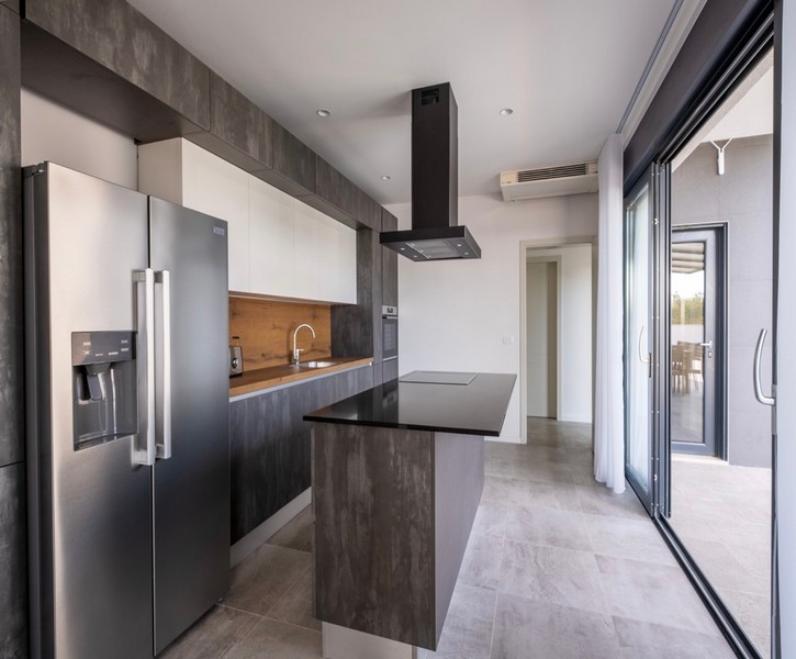 Nowoczesna kuchnia z wyspą kuchenną i wyjściem na taras