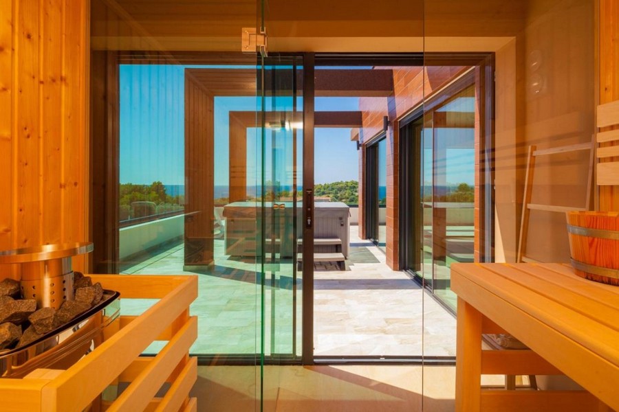 Sauna ze szklanym frontem i wyjściem na taras z widokiem na morze