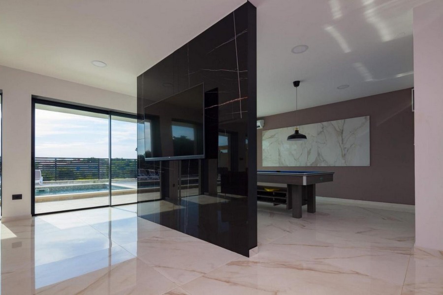 Otwarta część dzienna z nowoczesnymi elementami i widokiem na basen