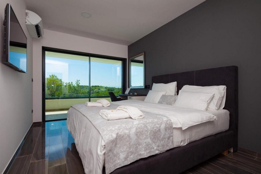 Elegancka sypialnia z podwójnym łóżkiem i widokiem na okolicę