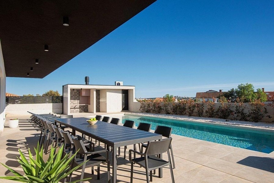 Taras z dużym stołem jadalnym i widokiem na basen