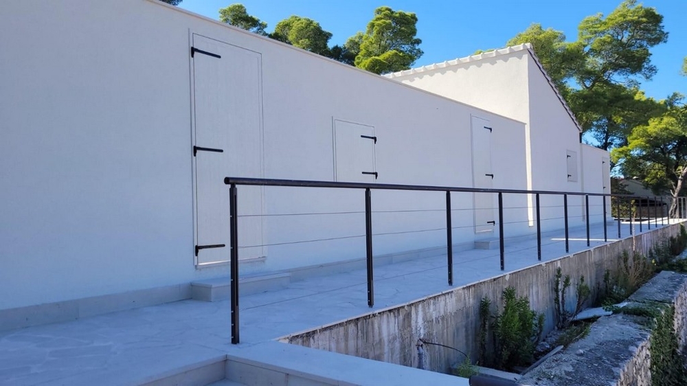 Wygląd zewnętrzny nowoczesnego domu z białą fasadą i poręczą