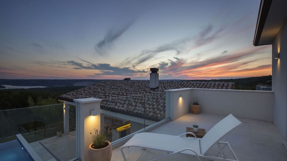 Taras willi z leżakami i panoramicznym widokiem na zachód słońca