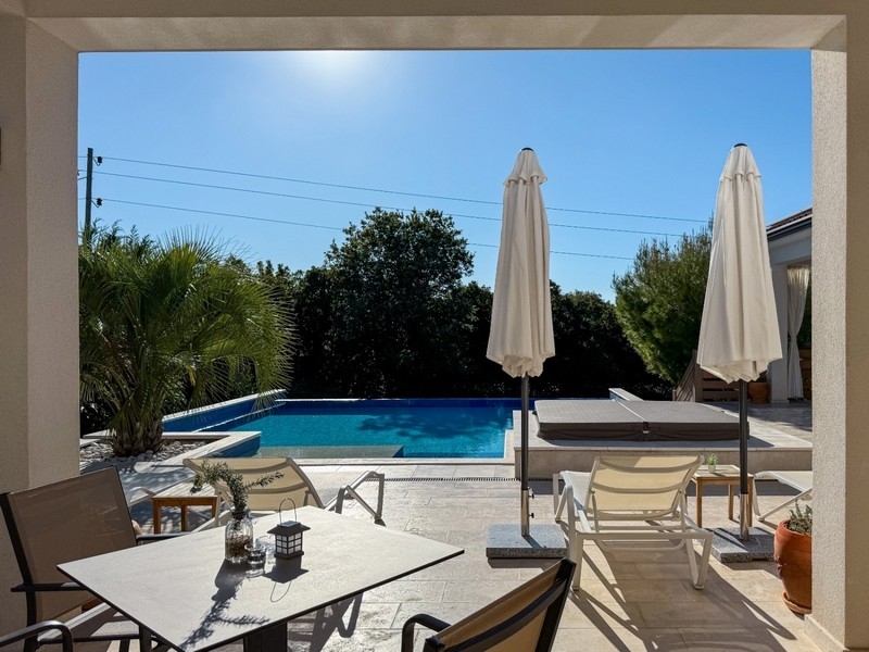 Zadaszony taras z częścią wypoczynkową i widokiem na basen