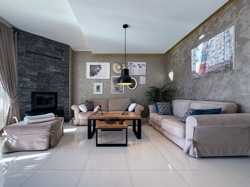 Pokój dzienny z kominkiem, sofami i stylowym wystrojem