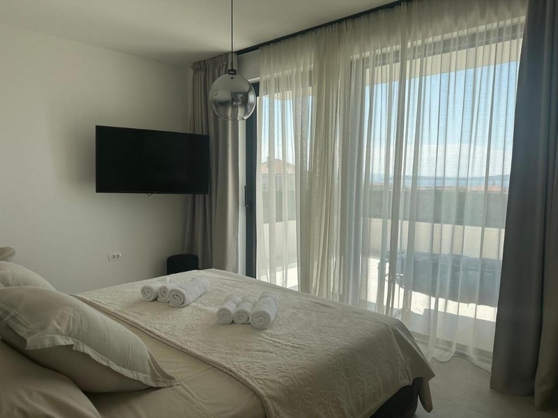 Sypialnia z balkonem i widokiem na morze przez duże okno z przodu