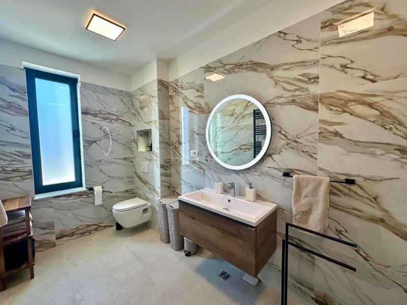 Nowoczesna łazienka z podwójnymi umywalkami i marmurowymi ścianami