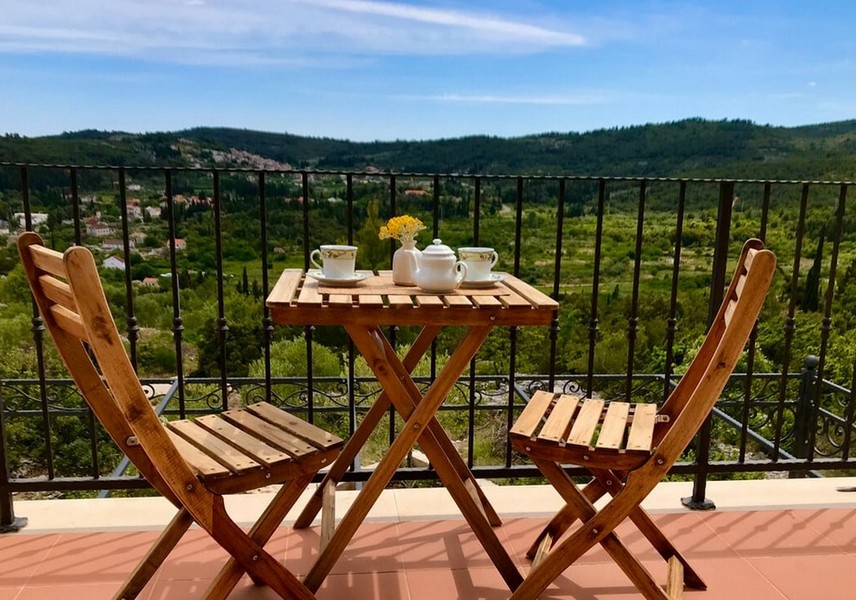 Balkon ze stołem i krzesłami, widok na wzgórza