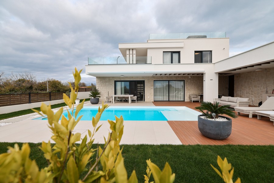 Widok z przodu nowoczesnej willi z basenem