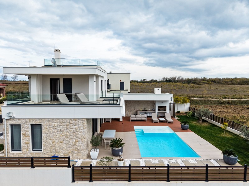 Widok z boku na willę z dużym tarasem i basenem