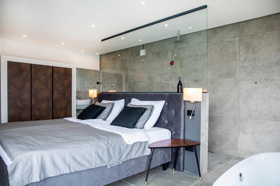 Szara sypialnia ze szklaną ścianą.