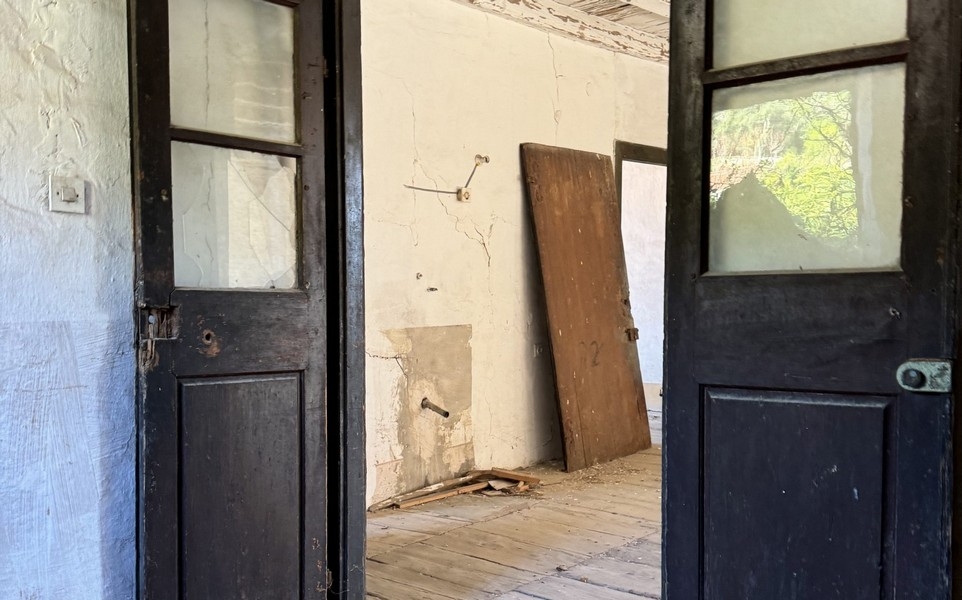 Wnętrze z otwartymi drzwiami i widoczną potrzebą remontu