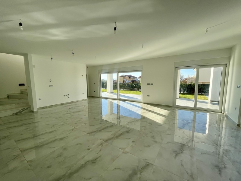 Jasny salon z oknami sięgającymi od podłogi do sufitu