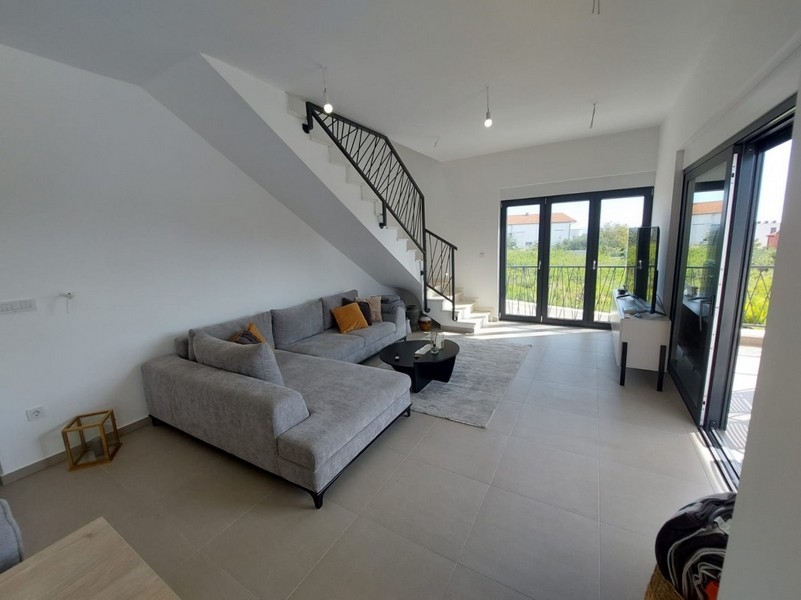 Jasny salon z sofą i schodami