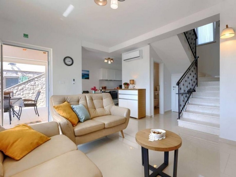 Część dzienna z sofą, schodami i wyjściem na taras