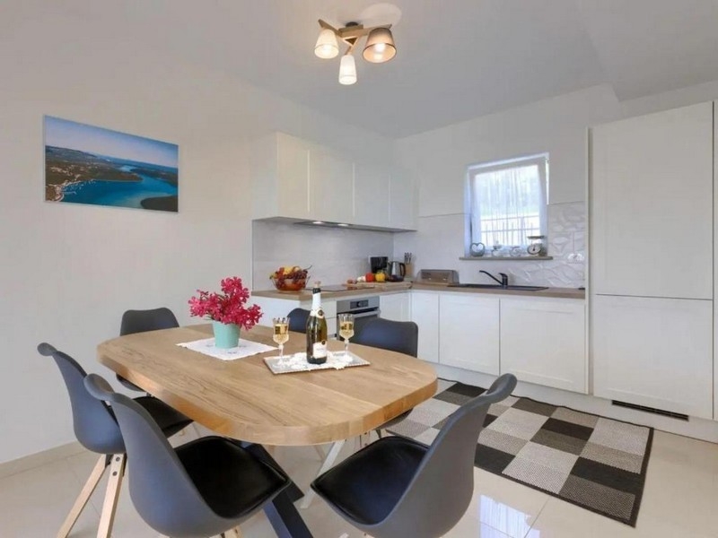 Jadalnia z drewnianym stołem i otwartą kuchnią