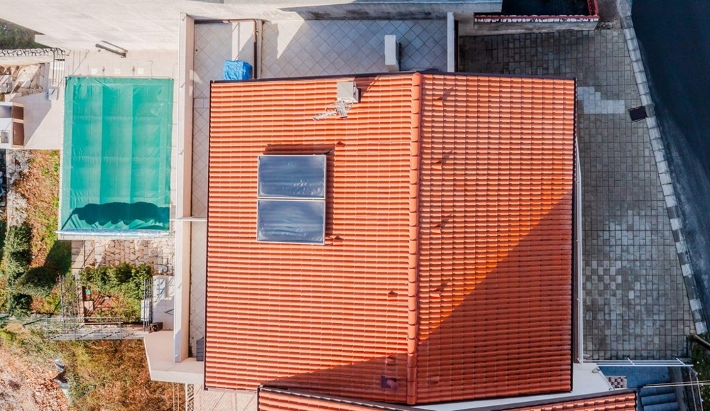 Widok z lotu ptaka na basen i czerwony dach pokryty dachówką w Crikvenicy