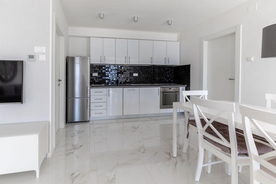 Nowoczesna kuchnia z białą wyposażoną kuchnią i jadalnią