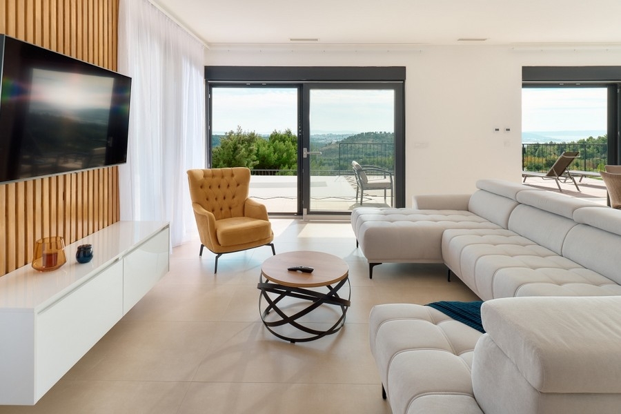 Otwarta część dzienna z oknami sięgającymi od podłogi do sufitu i wyjściem na taras