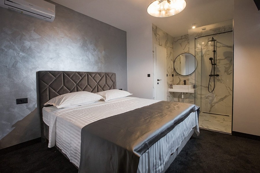 Sypialnia z podwójnym łóżkiem i otwartą łazienką