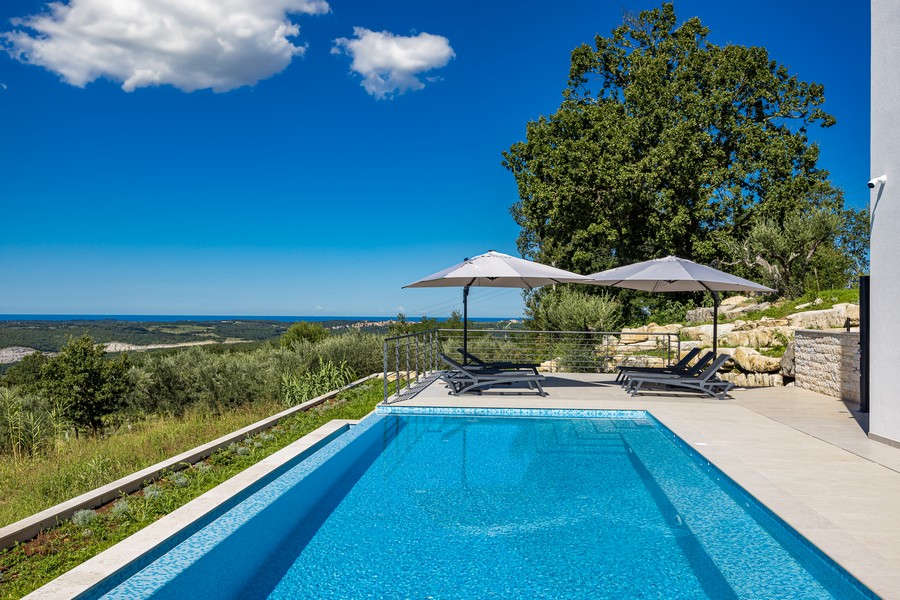 Przestronny basen z tarasem słonecznym i widokiem na morze