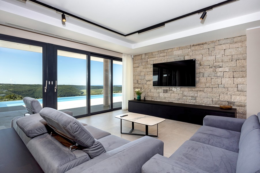 Salon z panoramicznymi oknami i widokiem na zieleń