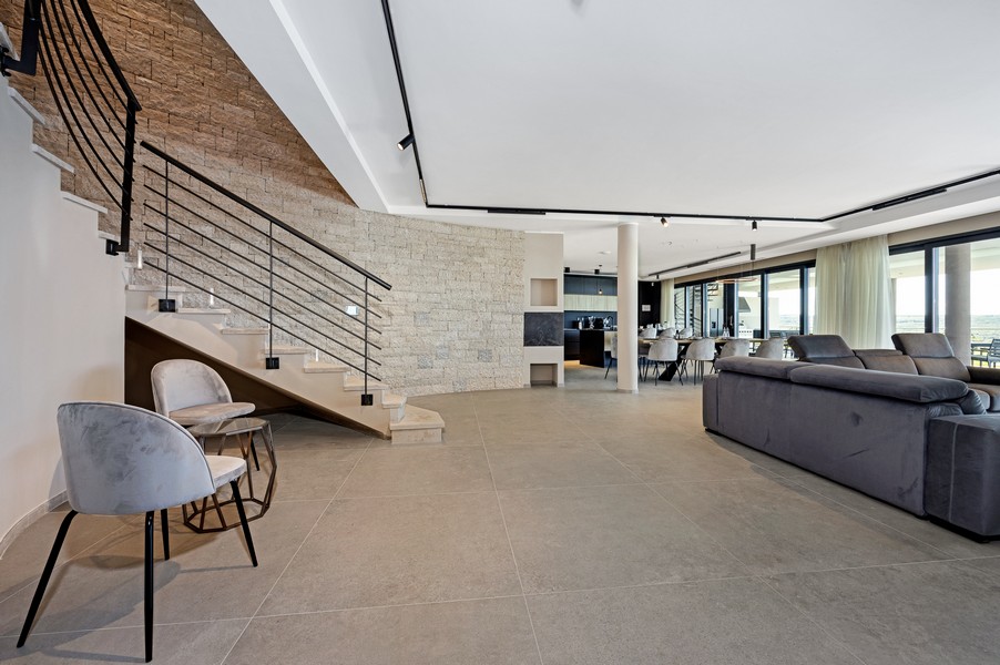 Otwarta część dzienna ze schodami i wysokiej jakości meblami