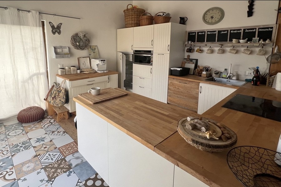 Nowoczesna kuchnia z wyspą kuchenną i drewnianym blatem